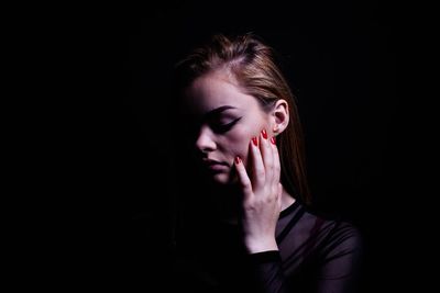 Woman looking away over black background