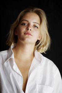 Portrait of a beautiful young woman over black background