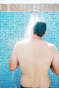 Rear view of shirtless man in swimming pool