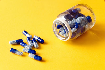 High angle view of pills on yellow background