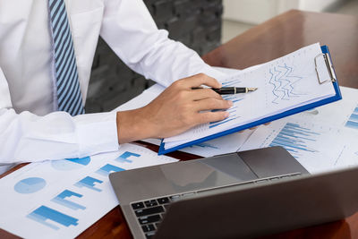 Midsection of business colleagues working on table