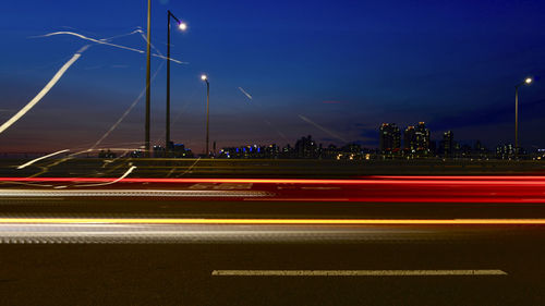 Light trails on road against sky at night