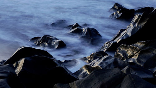 Scenic view of rocks on sea shore