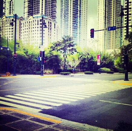 building exterior, architecture, city, built structure, street, road, transportation, road marking, city street, skyscraper, tree, city life, car, street light, office building, building, zebra crossing, modern, road sign, land vehicle