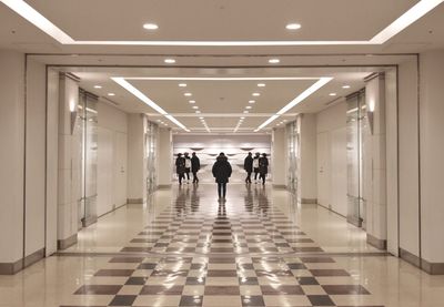 Rear view of people walking in corridor