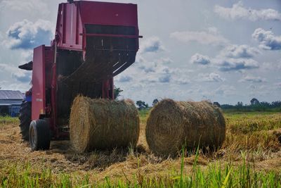 Round baler with hay bales on agricultural field