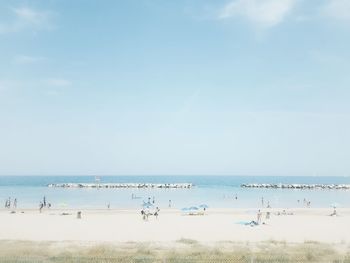 Group of people on beach against sky