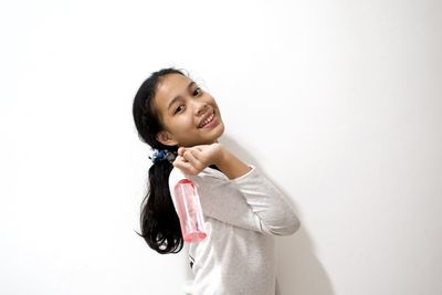 Portrait of a smiling young woman over white background