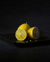 Close-up of fruits on table against black background