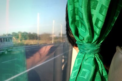 Close-up of boy by green curtain traveling in bus