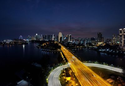 High angle view of illuminated street amidst buildings at night