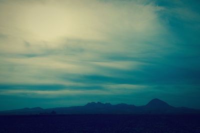 Scenic view of mountains against cloudy sky