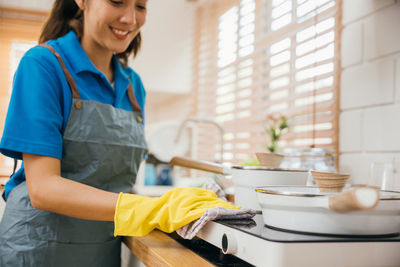 Portrait of young woman preparing food in kitchen