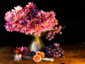 Close-up of flowers in vase on table against black background