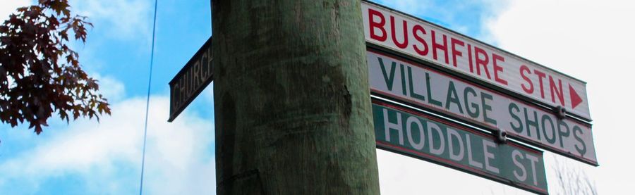 Low angle view of sign board against sky