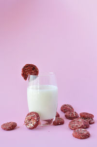Close-up of wine and cookies on table against gray background