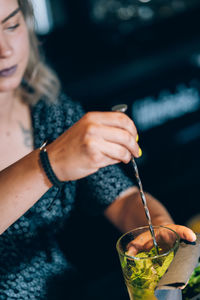 Waitress preparing a mojito cocktail in a bar.