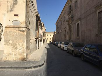 Street amidst buildings in city against clear sky