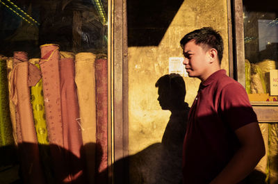 Portrait of teenage boy drinking glass window