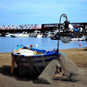 Boats moored at harbor against sky