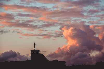 Low angle view of silhouette building against dramatic sky