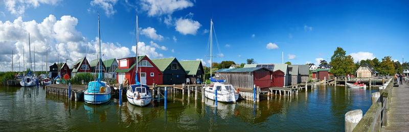 Panoramic view of boats moored in river against sky