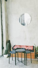 Empty chairs and table against wall in building
