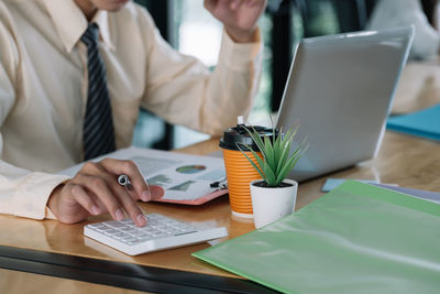 Midsection of businessman working on table