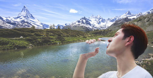 Digital composite image of man drinking water against river 