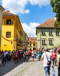 People walking on street against buildings in city