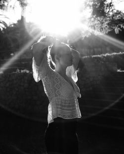 Low angle view of woman standing against bright sun