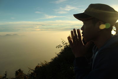 Portrait of man wearing hat against sky during sunset