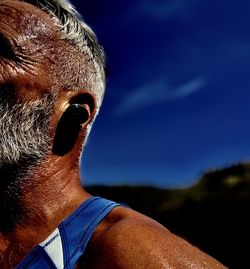 Close-up portrait of man against blue sky