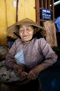 Portrait of man wearing hat sitting outdoors