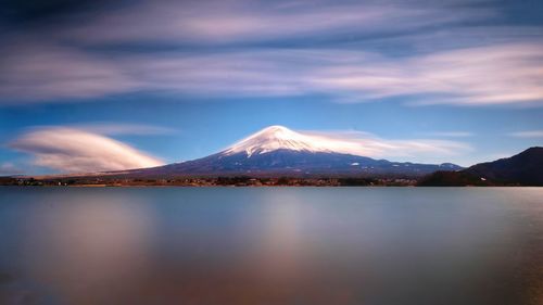 Scenic view of lake and snowcapped mountains against sky