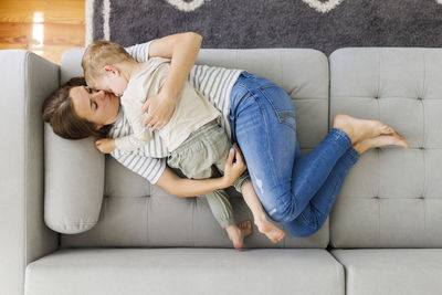 Portrait of mother and daughter sitting on sofa at home