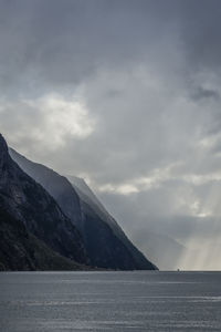 Scenic view of lysefjord and mountains against cloudy sky
