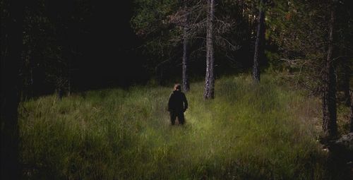 Rear view of man walking on field