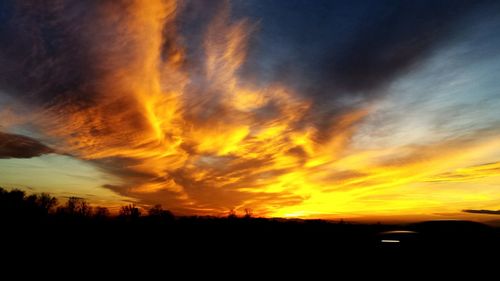 Scenic view of silhouette trees against sky at sunset