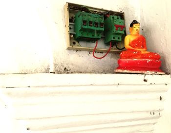 Buddha sculpture against fuse box