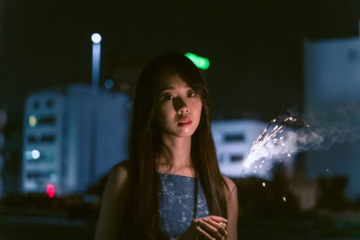 Portrait of a young woman looking away at night