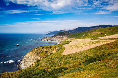 Scenic view of sea and mountains against sky