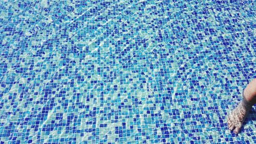 Low section of woman swimming in pool