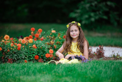 Portrait of girl with flowers on field