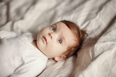 Portrait of cute baby lying on bed