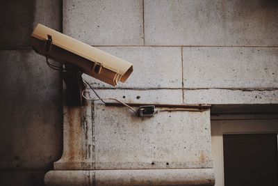 Low angle view of security camera mounted on building