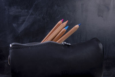 Close-up of colored pencils on table against black background