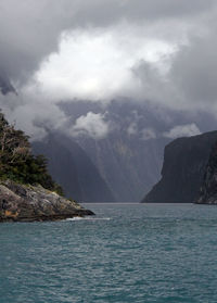 Scenic view of sea and mountains against cloudy sky