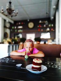 Portrait of girl with ice cream in glass on table