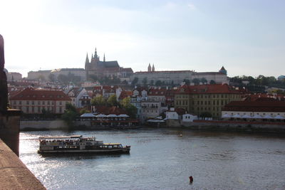 Boats in river with buildings in background